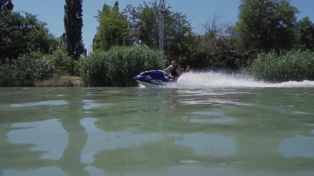 a young guy is riding a hydrocycle on the lake