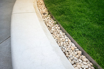 White curve stone bench decorated with white gravel and lawn. for public space.