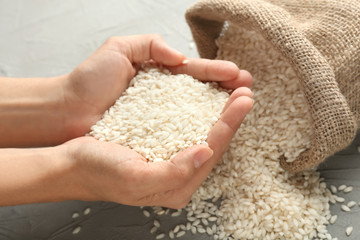 Female hands with heap of raw rice, closeup