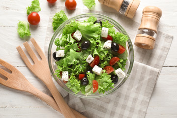 Bowl with delicious fresh salad on table