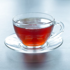A glass mug with hot black tea