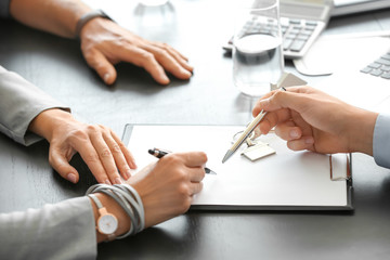 Mature couple signing document in estate agent's office