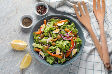 Bowl with fresh vegetable salad on light table