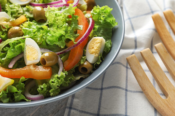 Bowl with fresh vegetable salad on table, closeup