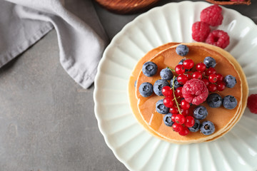 Plate with tasty homemade pancakes and berries on table