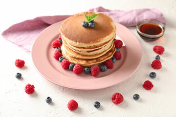 Plate with tasty homemade pancakes and berries on table