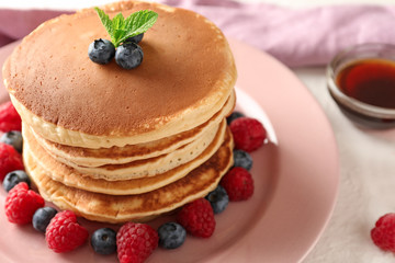 Tasty homemade pancakes with berries on plate, closeup