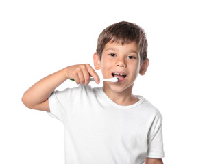 Cute little boy brushing teeth on white background