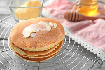 Cooling rack with tasty pancakes on wooden table
