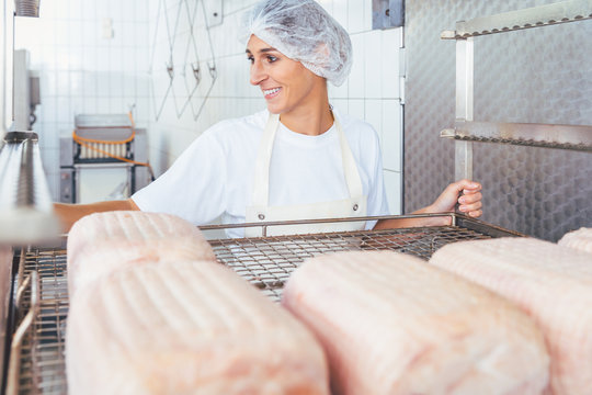 Woman in butchery processing meat ready to be smoked