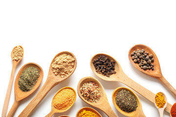 Wooden spoons with different spices on white background