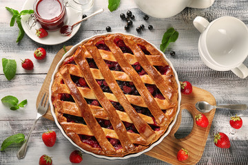 Tasty pie with berries on wooden table
