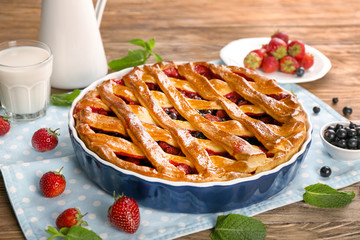 Tasty pie with berries on wooden table