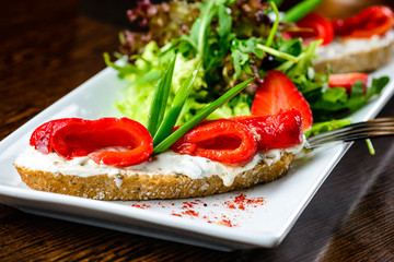 Delicious dish. Fresh bread with pepper served with sauce, straw