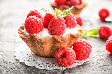 Tasty tartlet with raspberries on table