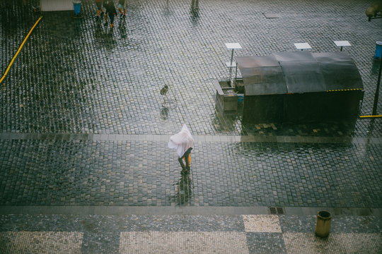 Gens dans rue pavée  sous la pluie