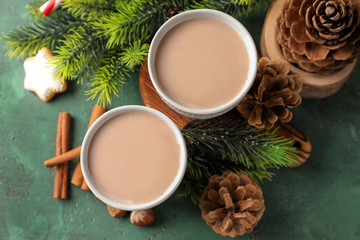 Cups of hot cocoa with fir tree branches and cones on table