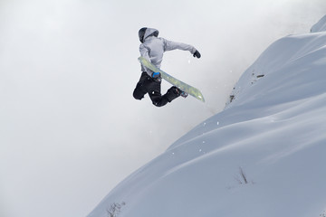 Flying snowboarder on mountains. Extreme winter sport.