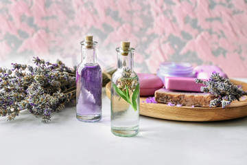 Obraz na płótnie Canvas Bottles of essential oil with lavender on table