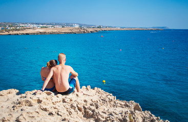 Fototapeta na wymiar Romantic couple sitting together on a rock