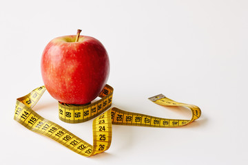 Measure tape and fresh fruit apple on white background. Loss weight, slim body, healthy diet concept