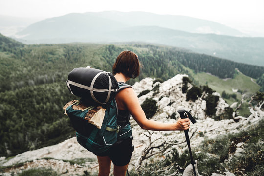 Junge Frau mit Gep&auml;ck wandert &uuml;ber einen Fels zum Hohenstaufen mit Blick auf die Berchtesgadener Alpen