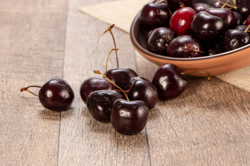 fresh cherry in wood bowl on wooden background 