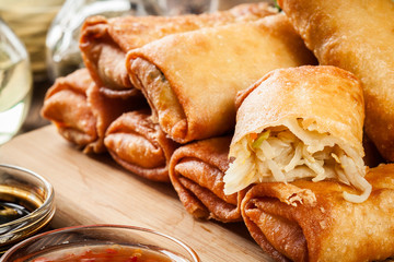 Spring rolls with chicken and vegetables on chopping board