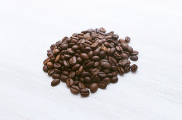 Coffee beans isolated on white wooden table background.