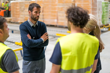 Warehouse manager talking to employees