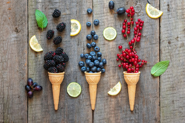 Berries in ice cream cones (blackberry, blueberry, redcurrant). Healthy summer food concept.