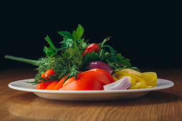 White plate with vegetable salades. Tomato and cucumber with olive oil dill onion and parsley