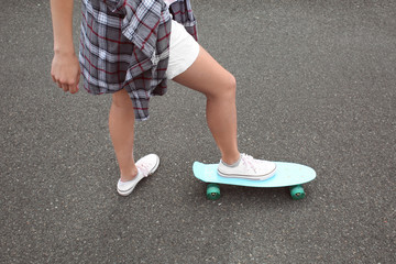 Hipster girl riding skateboard outdoors