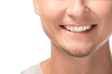 Man with healthy teeth smiling on white background, closeup
