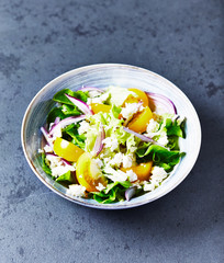 Yellow tomato salad with lettuce, red onion and feta cheese. Homemade food