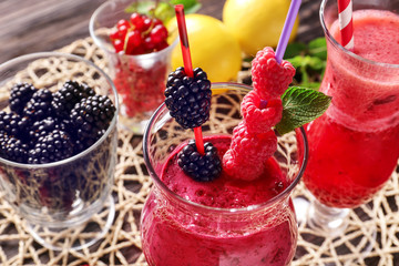 Glass with tasty berry smoothie on table, closeup