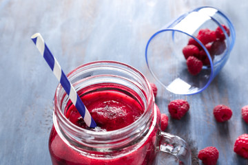Mason jar with tasty raspberry smoothie on wooden table