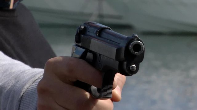 Close up of a criminal pointing a gun and then is disarmed