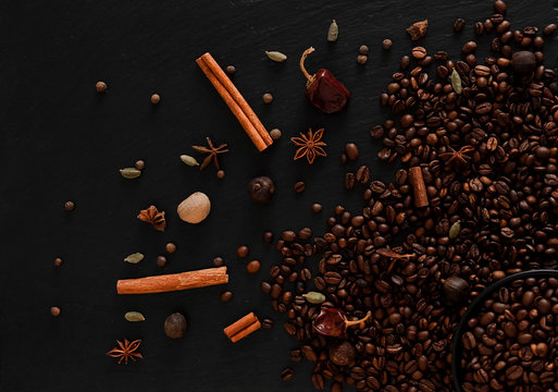 Coffee beans flatlay. Warm photo with coffee beans and spices on dark texturised background.