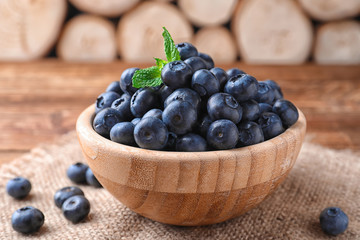 Bowl with ripe blueberries on table