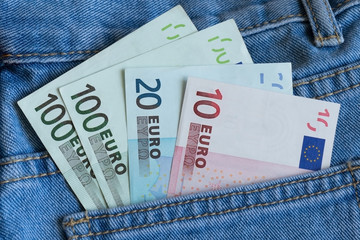  Euro banknotes in blue jeans pocket closeup. Back jeans pocket full of euro banknotes. Euro money