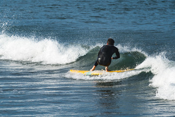 Surf teacher in small wave.