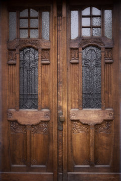 old oak doors with glass windows and wrought iron bars