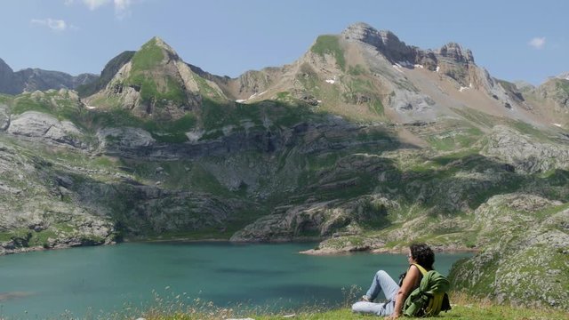 woman hiker looking at Lake Estaens in the Pyrenees mountains.
