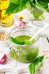 Homemade pesto sauce fresh basil, pine nuts and garlic on white wooden background. Italian food.