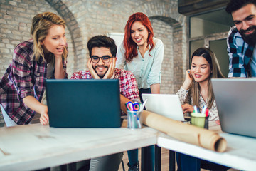 College students using laptop while sitting at table. Group study for school assignment.