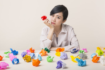 色とりどりの紙を前に困った表情をする若い女性