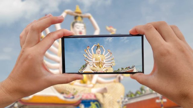 Cinemagraph of Taking Mobile Photo of Guan Yin Statue at Plai Laem Temple - Main Symbol and Popular Landmark of Samui Island in Thailand. Tourism and Sightseeing