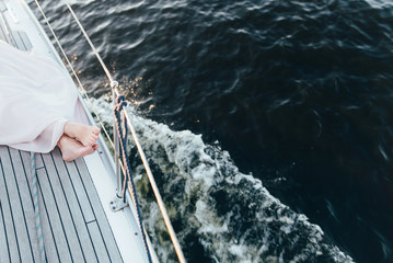 The legs of a woman lying on a yacht and resting on the background of the reservoir