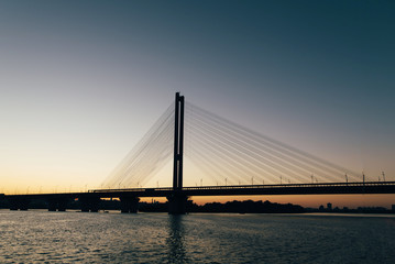 A huge bridge in the background of the sunset, which divides the city into two parts